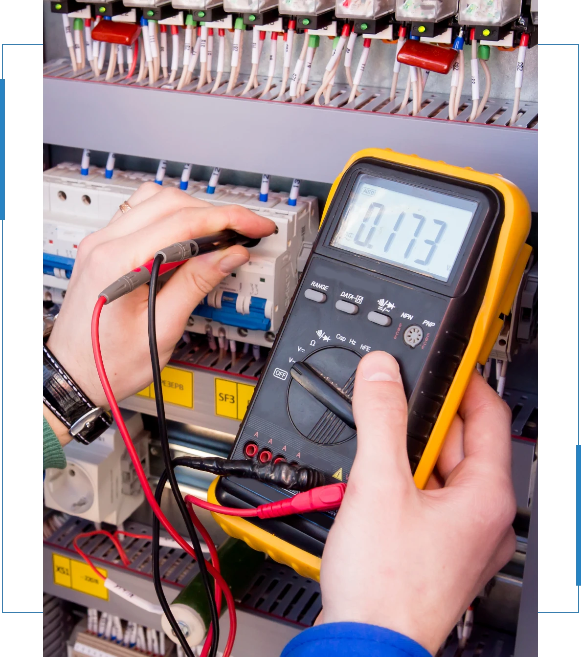 Electrician using a multimeter to test electrical circuits in a control panel, showcasing Pendleton Electric's expertise in electrical services and safety.